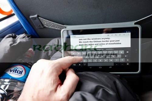 man using tablet computer to write blog whilst travelling on a bus in south america