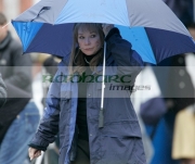 Shirley-MacLaine-shelters-from-the-rain-under-an-umbrella-on-location-for-Sir-Richard-Attenboroughs-latest-film-Closing-the-Ring-in-Belfast,-Northern-Ireland.