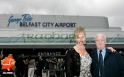 Barbara-McNarry-Dickie-Best-in-front-Belfast-City-Airports-new-logo-at-George-Best-airport-renaming-ceremony,-Belfast-City-Airport,-Belfast,-Northern-Ireland.