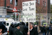 A-religious-protester-walks-in-police-lines-between-loyalist-republican-protesters-at-the-Royal-Irish-Regiment-RIR-Homecoming-Parade-in-Belfast-on-September-02,-2008-in-Belfast,-Northern-Ireland.-The-parade,-which-passed-relatively-peacefully,-was-for-troops-returning-from-Iraq-Afghanistan