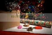 box-to-be-wrapped-up-with-scissors-wrapping-paper,-decorations-tape-in-front-christmas-tree