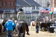 man-in-cowboy-hat-riding-horse-down-main-street-during-ballyclare-may-fair-county-antrim-northern-ireland