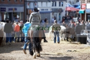man-in-cowboy-hat-riding-horse-down-main-street-during-ballyclare-may-fair-county-antrim-northern-ireland