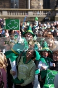 young-girl-in-fancy-dress-irish-costume-waving-flag-held-up-by-mother-in-the-crowd-at-the-concert-carnival-in-custom-house-square-on-st-patricks-day-belfast-northern-ireland