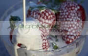 pouring-cream-over-strawberries-fresh-cream-served-outdoors-in-the-evening-in-the-uk