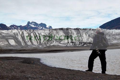 mid 40s grey haired photographer single male tourist walking near skaftafellsjokull glacier skaftafell vatnajokull national park iceland