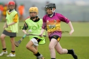 young-boy-wearing-protective-helmet-running-with-the-sliothar-ball-on-his-caman-stick-during-hurling-game