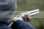 man-in-woolen-hat-takes-aim-with-shotgun-on-december-shooting-day,-county-antrim,-Northern-Ireland