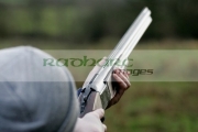 man-in-woolen-hat-takes-aim-with-shotgun-on-december-shooting-day,-county-antrim,-Northern-Ireland