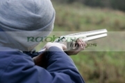 man-in-woolen-hat-takes-aim-with-shotgun-on-december-shooting-day,-county-antrim,-Northern-Ireland