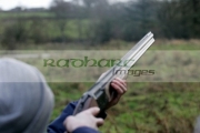 man-in-woolen-hat-takes-aim-with-shotgun-on-december-shooting-day,-county-antrim,-Northern-Ireland
