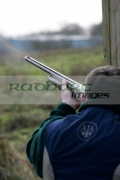 Man-fires-shotgun-with-flames-coming-out-the-barrel-in-shooting-stand-on-december-shooting-day,-county-antrim,-Northern-Ireland