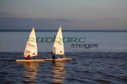 two-laser-class-sailing-boats-from-gbr-IRL-great-britain-ireland-sailing-in-evening-sun-with-reflection-on-the-water