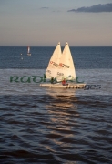 two-laser-class-sailing-boats-from-gbr-IRL-great-britain-ireland-sailing-in-evening-sun-with-reflection-on-the-water