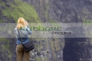 blonde-haired-female-tourist-taking-photos-at-the-Cliffs-Moher,-County-Clare,-Republic-Ireland