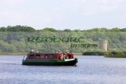 tourist-steering-narrowboat-barge-past-Crichton-Tower-on-Gad-Island-part-the-Crom-Castle-estate-lower-lough-erne