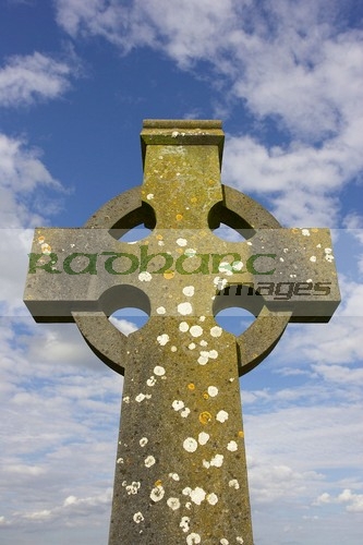 high-stone-celtic-cross-against-blue-cloudy-sky-in-the-Rock-Cashel,-Cashel,-County-Tipperary,-Republic-Ireland