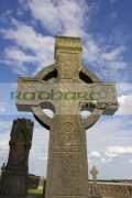 high-stone-celtic-cross-against-blue-cloudy-sky-in-the-Rock-Cashel,-Cashel,-County-Tipperary,-Republic-Ireland