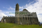 12th-century-round-tower-13th-century-cathedral-against-blue-cloudy-sky-in-the-Rock-Cashel,-Cashel,-County-Tipperary,-Republic-Ireland