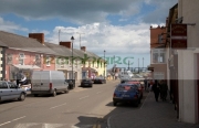 cars-parked-tourists-walking-up-down-main-street-courtown-traditional-seaside-resort-village