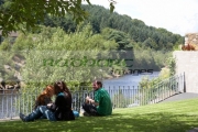 three-foreign-tourists-make-an-impromptu-lunch-picnic-sitting-on-grass-lawn-in-front-fence-overlooking-river-in-vale-avoca