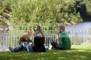 three-foreign-tourists-make-an-impromptu-lunch-picnic-sitting-on-grass-lawn-in-front-fence-overlooking-river-in-vale-avoca