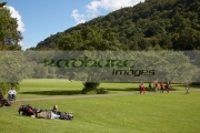 tourists-lying-on-the-grass-others-walking-along-pathway-beneath-the-hills-on-open-ground-in-grounds-glenalough-monastic-site