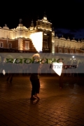 three-female-fire-dancers-street-entertainers-perform-in-front-crowd-at-the-cloth-hall-in-krakow