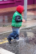 young-boy-splashing-through-puddles-in-rain-shower-in-the-uk