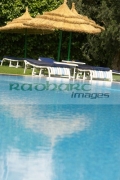 vertical-sun-loungers-straw-parasols-by-the-poolside-in-resort-hotel-hammamet-tunisia