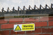 warning-sign-anti-climb-spikes-on-wall-property-Liverpool-England-UK